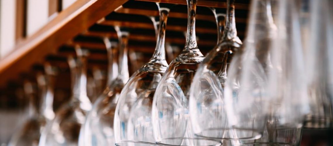 empty-glasses-for-wine-above-a-bar-rack-hanging-PMWRAPK