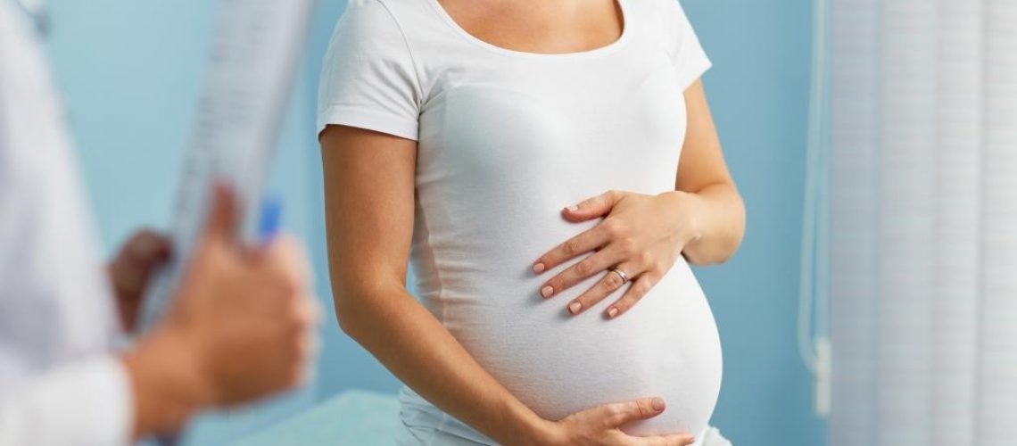 storyblocks-pregnant-woman-with-hands-on-stomach-talking-to-obstetrician_BnOL_ByJM